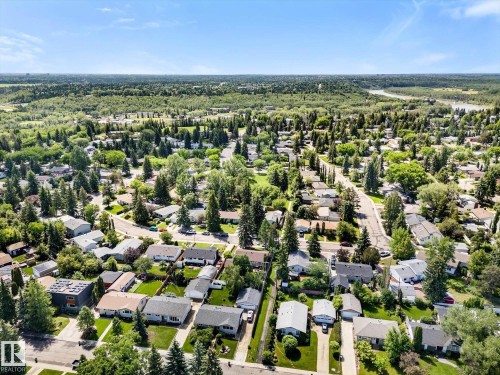 Aerial perspective showcasing a residential neighborhood with mature trees and a river visible in the distance - 15112 76A Avenue, Edmonton, AB 