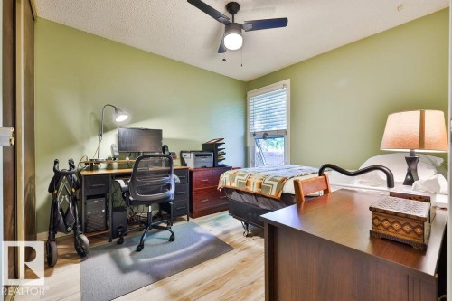 Bedroom featuring light green walls and wood-finish flooring - 17009 109 Street, Edmonton, AB 