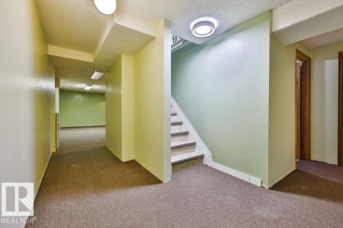 Carpeted hallway with light green walls and white trim - 17009 109 Street, Edmonton, AB 