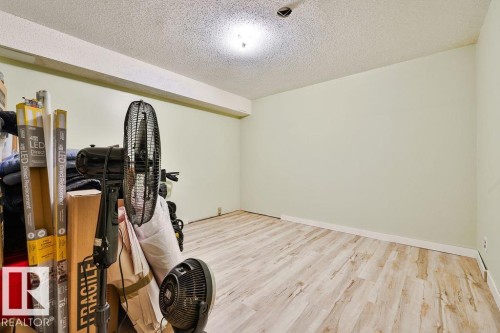 Spacious room featuring light wood-finish flooring and light green painted walls - 17009 109 Street, Edmonton, AB 