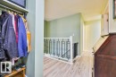 Hallway with light wood-finish flooring, light green painted walls, and textured ceiling - 17009 109 Street, Edmonton, AB 