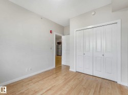 Room featuring wood-finish flooring, light-toned walls, white baseboards, and a double bi-fold closet - 