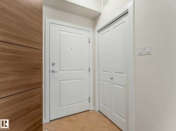 Entryway featuring a paneled door, bi-fold closet doors, light wood-finish flooring, and a contemporary light switch panel - 