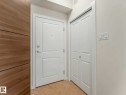 Entryway featuring a paneled door, bi-fold closet doors, light wood-finish flooring, and a contemporary light switch panel - 406 9519 160 Avenue, Edmonton, AB 