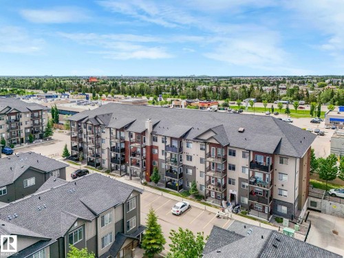 Multi-story condominium building featuring private balconies, designated parking, and a contemporary exterior with varied siding materials - 406 9519 160 Avenue, Edmonton, AB 