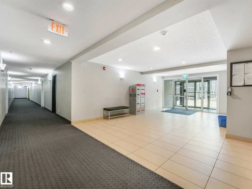 Entryway featuring light-toned tile flooring, recessed lighting, and glass double doors - 406 9519 160 Avenue, Edmonton, AB 