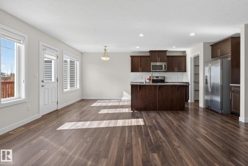 Open-concept living space featuring wood-finish flooring throughout - 5306 67 Street E, Beaumont, AB 