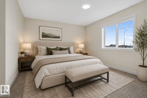 Carpeted room featuring a large window with white trim, a flush-mount ceiling light, and light-toned wall paint - 5306 67 Street E, Beaumont, AB 