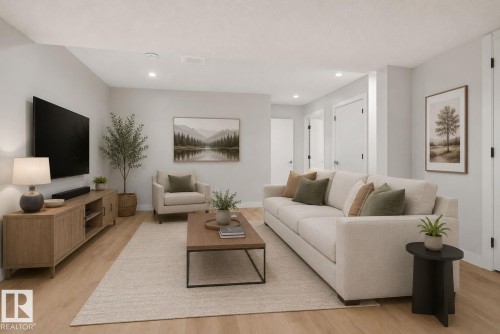 Spacious living area featuring light-toned walls, recessed lighting, and wood-finish flooring - 5306 67 Street E, Beaumont, AB 