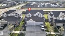 Two-story residence featuring a gray exterior with cream trim accents - 5306 67 Street E, Beaumont, AB 