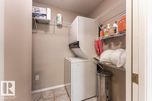 Dedicated laundry area featuring a stacked washer and dryer unit - 101 10421 42 Avenue, Edmonton, AB 