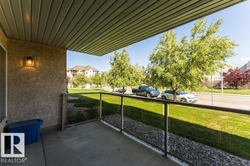 Covered patio featuring concrete flooring and a glass panel railing - 101 10421 42 Avenue, Edmonton, AB 