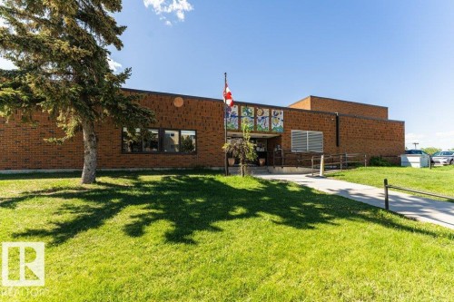 Brick exterior building featuring multiple windows and a prominent entrance - 101 10421 42 Avenue, Edmonton, AB 