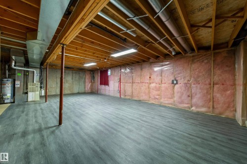 Spacious unfinished basement featuring exposed wood joists, concrete walls, and insulated wall sections - 120 13320 124 Street Nw, Edmonton, AB 