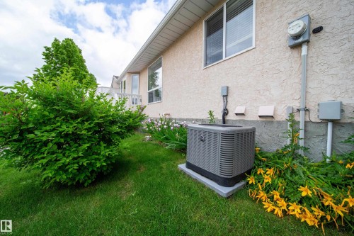 Stucco exterior with multiple windows and a visible HVAC unit - 120 13320 124 Street Nw, Edmonton, AB 