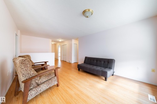 Spacious interior featuring wood-finish flooring, neutral wall tones, and recessed ceiling lighting - 120 13320 124 Street Nw, Edmonton, AB 