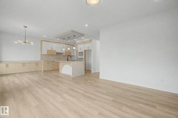 Expansive open-concept room featuring light wood-finish flooring - 