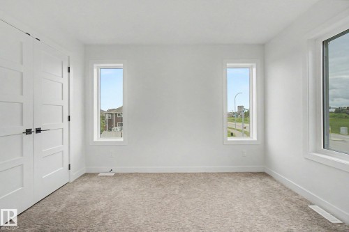 Bright interior space featuring light-colored carpet flooring and white walls - 2 Willow Heights Drive, Stony Plain, AB 
