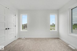 Bright interior space featuring light-colored carpet flooring and white walls - 