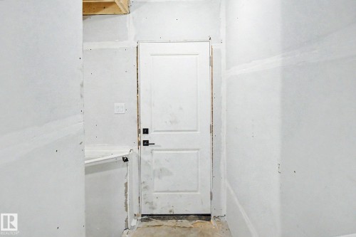 Two-panel interior door with square hardware, surrounded by drywall ready for finishing - 2 Willow Heights Drive, Stony Plain, AB 
