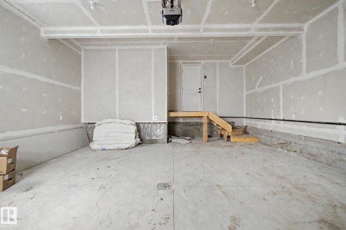 Unfinished garage space featuring a concrete floor, drywall-finished walls, and exposed ceiling joists - 2 Willow Heights Drive, Stony Plain, AB 