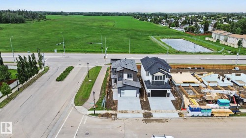 Newly constructed residential property featuring a dark gray and white exterior, an attached garage, a paved driveway, and a partially landscaped front yard - 2 Willow Heights Drive, Stony Plain, AB 