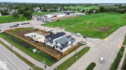 Recently constructed multi-story residential buildings featuring contemporary architectural styling, dark shingle roofing, and light-colored siding - 