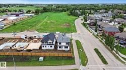 Contemporary two-story homes featuring dark shingle roofs and light-colored siding - 