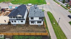 Two new construction residences featuring contrasting dark and light siding with black window trim - 