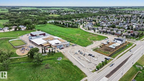 Aerial perspective showcasing a structured development amidst green spaces and established residential areas - 2 Willow Heights Drive, Stony Plain, AB 