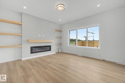 Living space featuring a built-in electric fireplace, integrated floating shelves, and wood-finish flooring - 