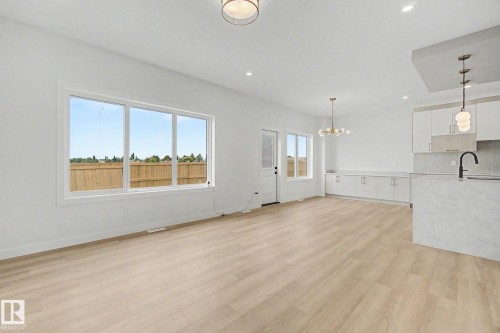 Open-concept living space featuring wood-finish flooring, white walls, and contemporary light fixtures - 2 Willow Heights Drive, Stony Plain, AB 