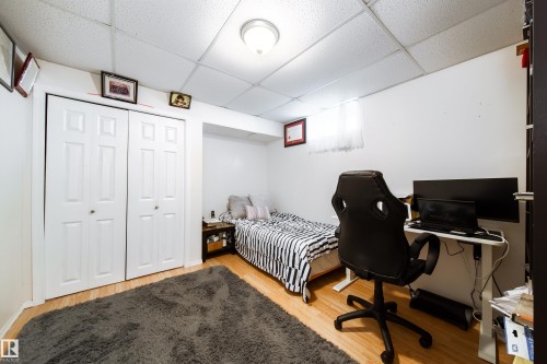 Room featuring wood-finish flooring, white walls, and a drop ceiling with recessed lighting - 5607 188A Street, Edmonton, AB 