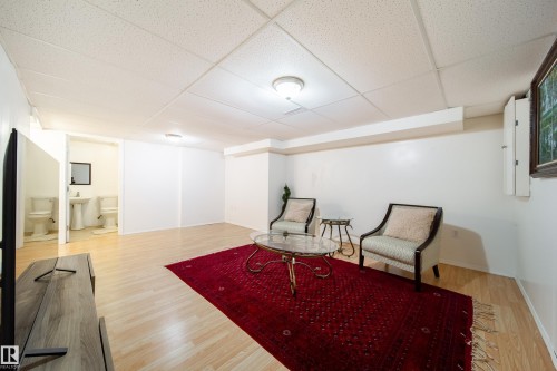 Spacious room featuring light wood-finish flooring, white walls, and a dropped ceiling with recessed lighting - 5607 188A Street, Edmonton, AB 