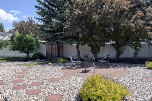 Backyard featuring a circular paver patio, gravel ground cover, and stepping stones - 5607 188A Street, Edmonton, AB 