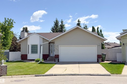 Contemporary home exterior featuring neutral siding with brick accents and a prominent two-car garage - 5607 188A Street, Edmonton, AB 