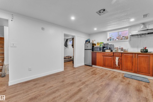 Kitchenette featuring wood-finish flooring, recessed lighting, and a window for natural light - 9606 161 Street, Edmonton, AB 