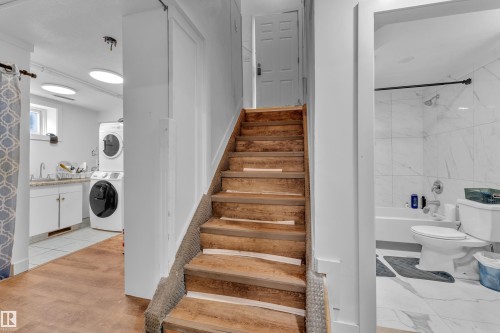Hardwood staircase with integrated carpet runner leads to an upper level - 9606 161 Street, Edmonton, AB 