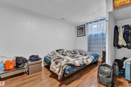 Room featuring wood-finish flooring, white paneled walls, and a recessed window - 9606 161 Street, Edmonton, AB 