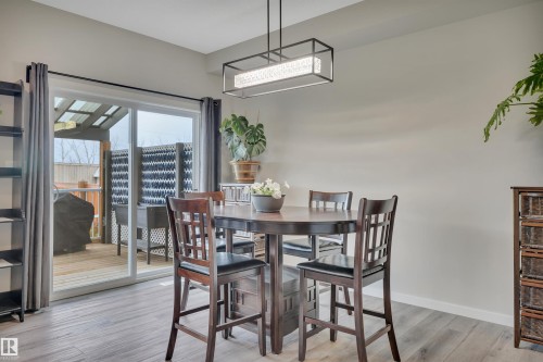Dining area featuring wood-finish flooring and a rectangular pendant light fixture - 157 Larch Crescent, Leduc, AB 