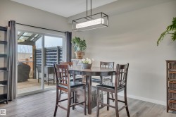 Dining area featuring wood-finish flooring and a rectangular pendant light fixture - 