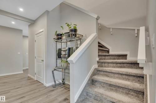 Inviting entryway featuring wood-finish flooring, a white paneled door, and recessed lighting - 157 Larch Crescent, Leduc, AB 