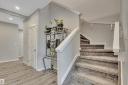 Inviting entryway featuring wood-finish flooring, a white paneled door, and recessed lighting - 