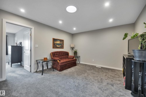 Carpeted room featuring recessed lighting, a circular ceiling light fixture, neutral wall finishes, and a white interior door frame - 157 Larch Crescent, Leduc, AB 