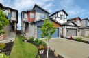 Modern two-story residence featuring a striking red and blue exterior with stone accents - 157 Larch Crescent, Leduc, AB 