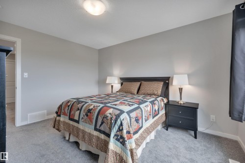 Bedroom featuring light gray walls, gray carpet flooring, and white trim - 157 Larch Crescent, Leduc, AB 