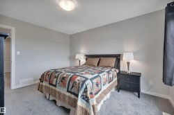 Bedroom featuring light gray walls, gray carpet flooring, and white trim - 