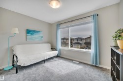 Carpeted room featuring a large window with roller shades and light blue drapes - 