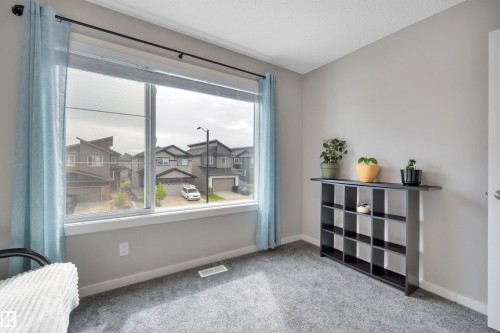Expansive window with light blue drapery and window coverings - 157 Larch Crescent, Leduc, AB 