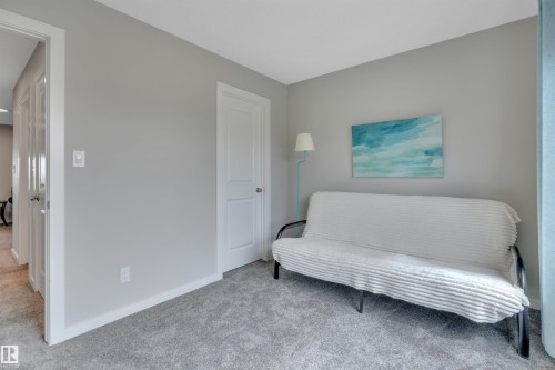 Carpeted room featuring light gray walls, white trim, and white interior doors - 157 Larch Crescent, Leduc, AB 